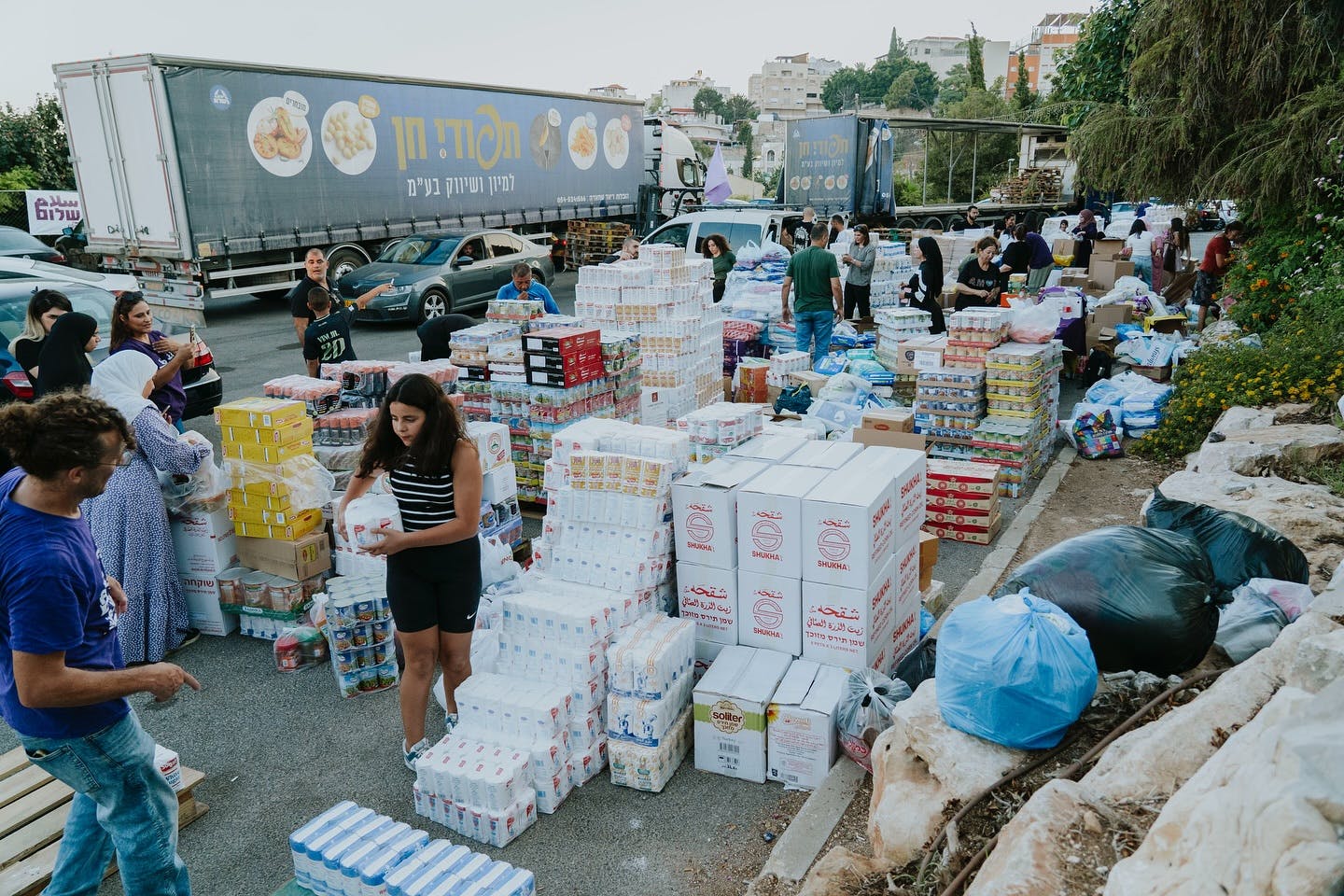 food packages, with people carrying some and a truck behind