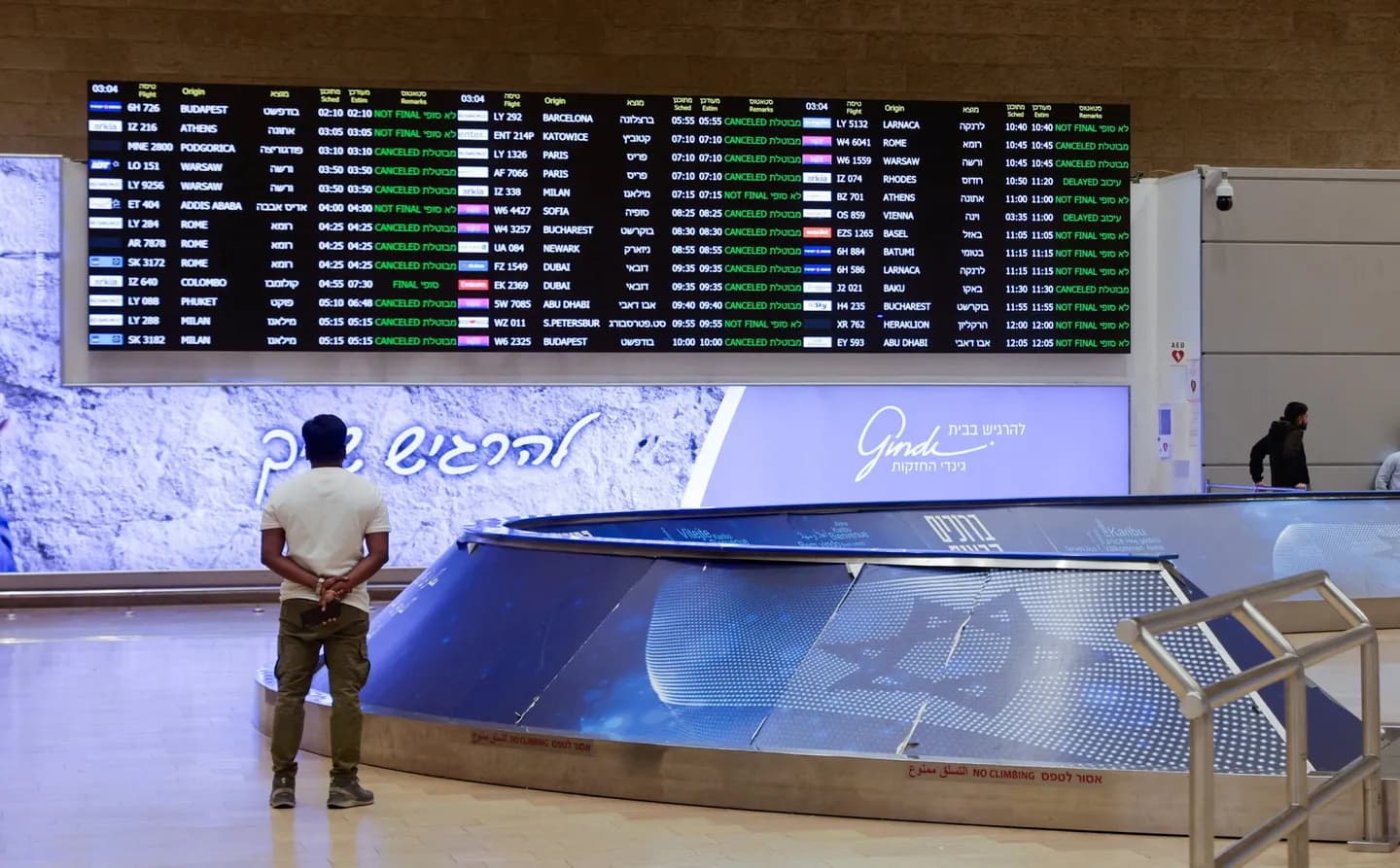 Man looking at airline arrivals board