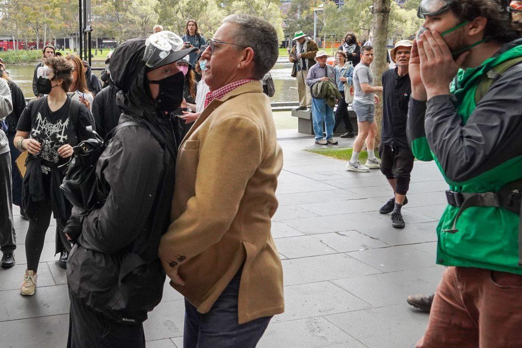 A protester pushes his body up against a Land Forces delegate, in an attempt to block him from entering the expo (Image: Ben Bresley).