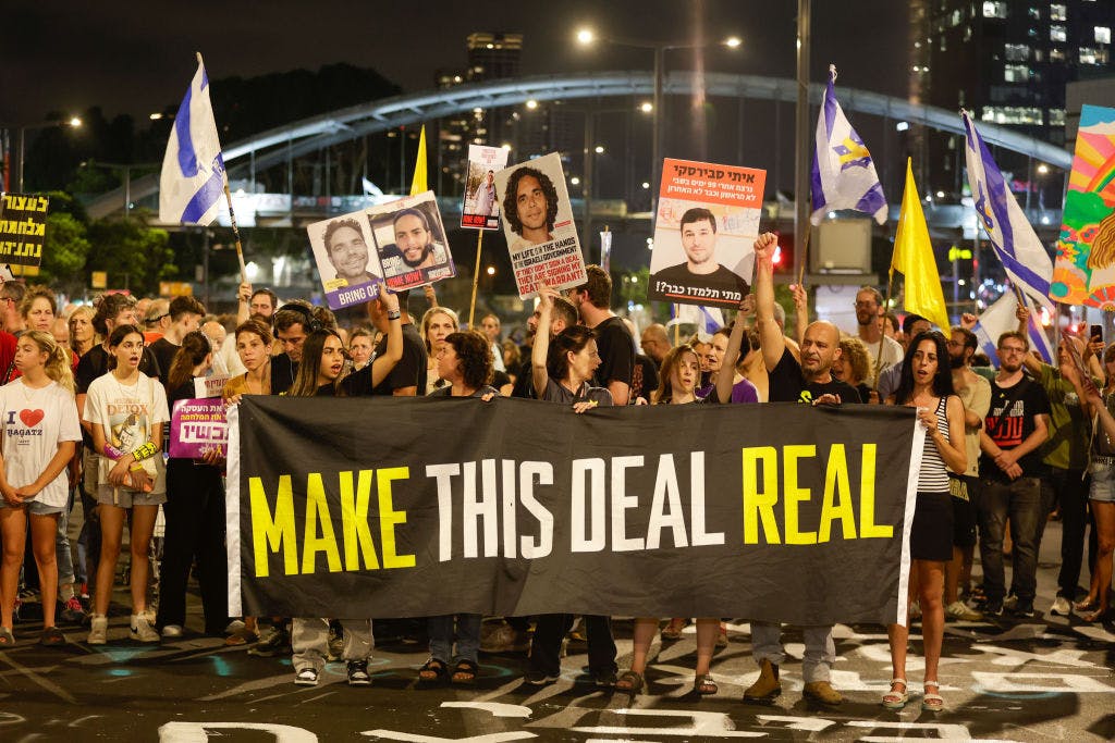 Crowds with Israeli flags, posters and a banner reading 'Make this Deal Real'