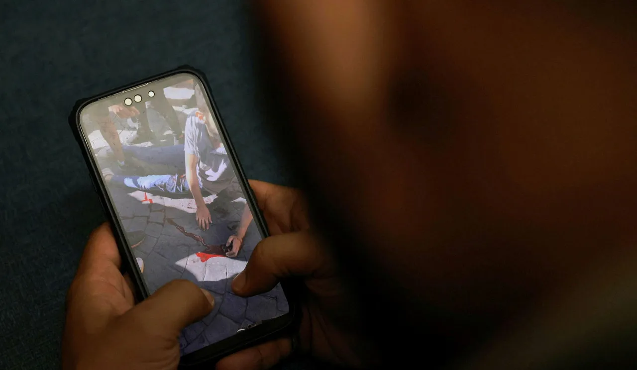 Mobile phone with screen showing bloody man on ground