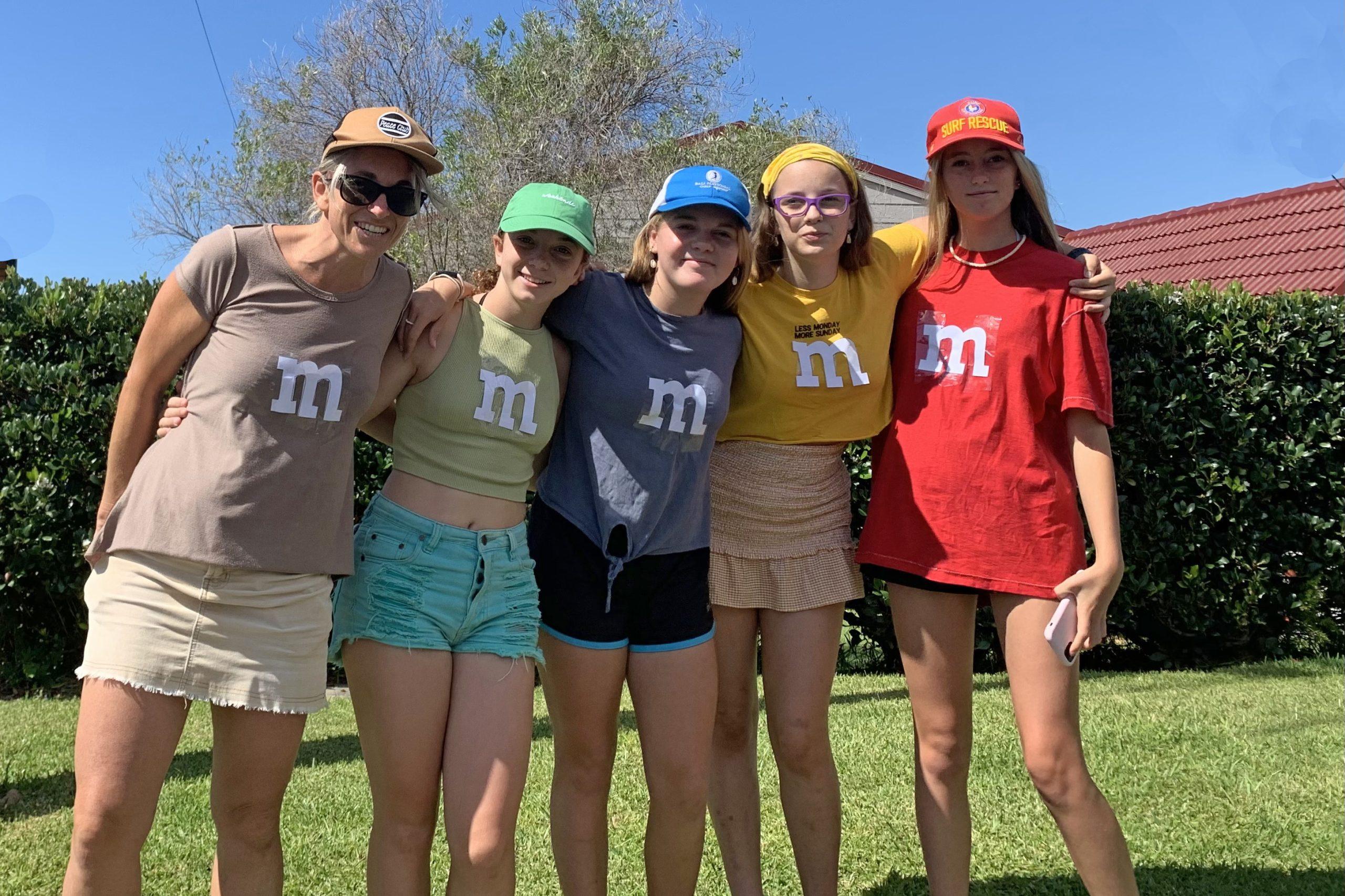 5 grils in shorts and colourful caps and t shirts