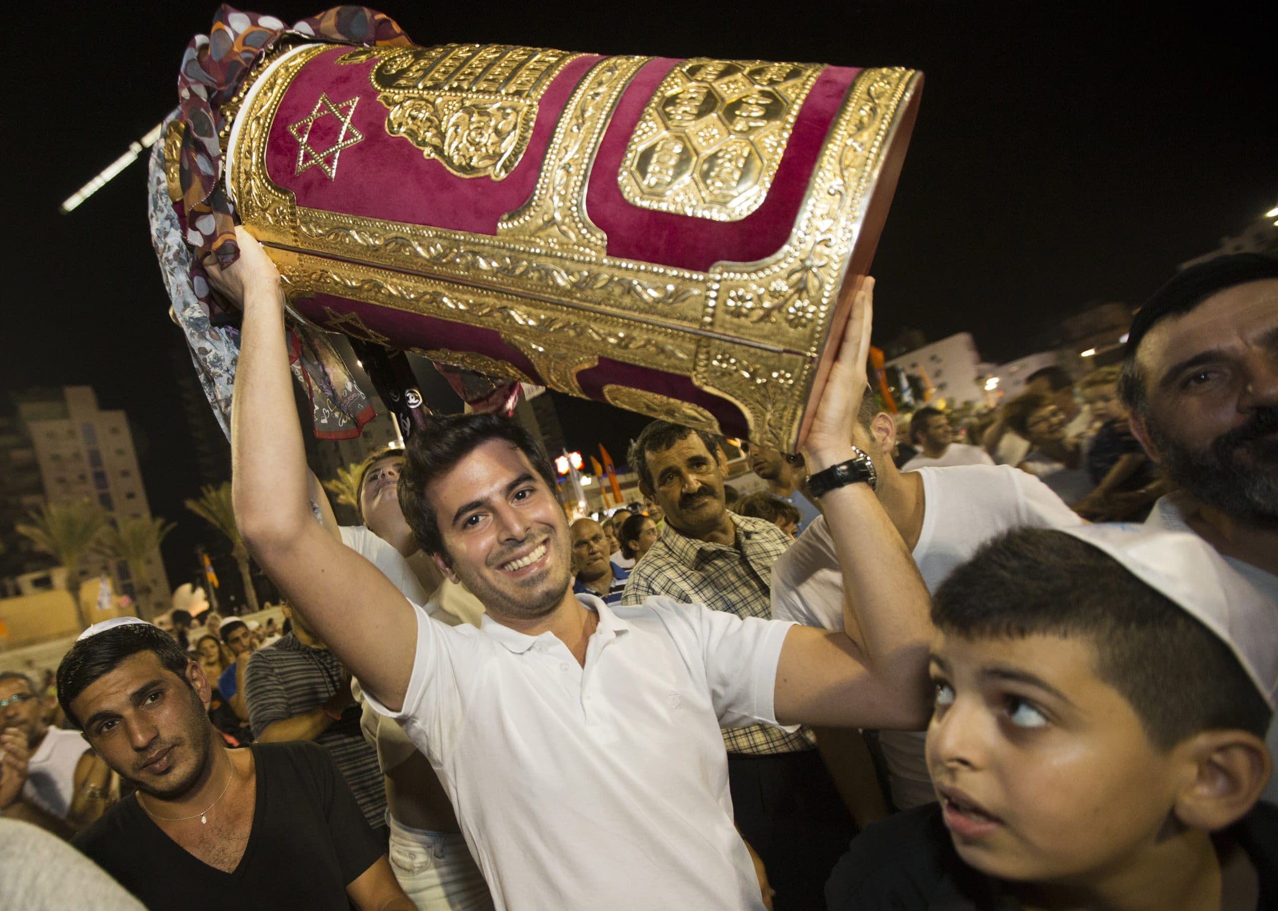 Simchat Torah celebrations in Netanya. A man smiling with a Torah.