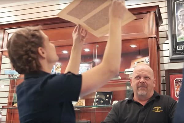 Rare-book authenticator Rebecca Romney inspects a Noble Fragment with Pawn Stars host Rick Harrison looking on, 2017 (History Channel)