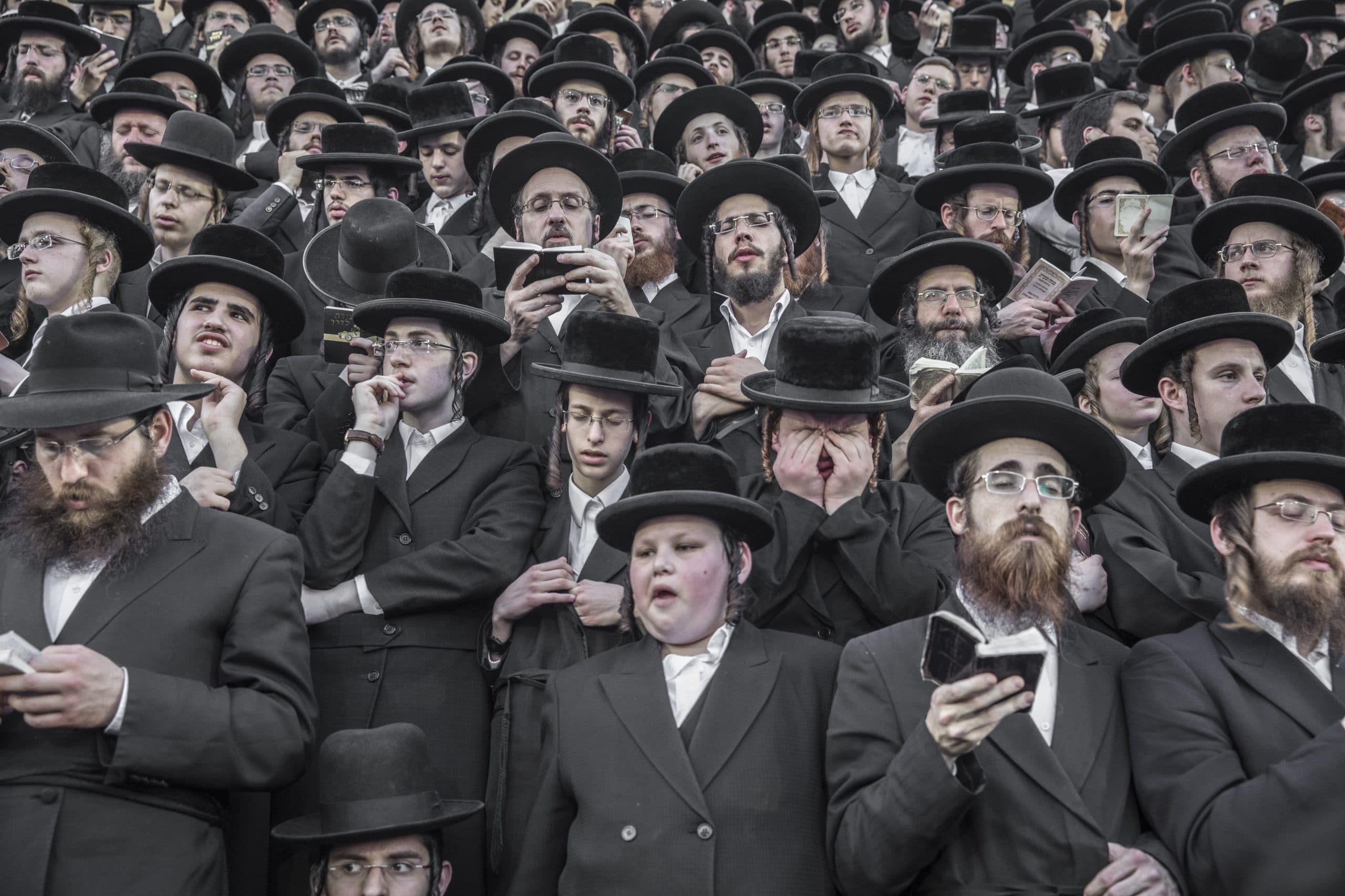 Crowd of men in black hats and coats